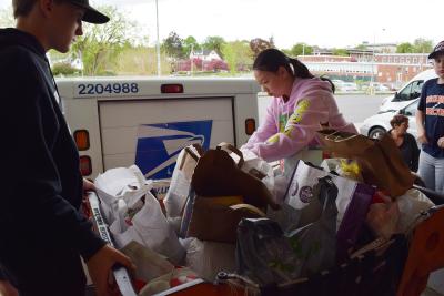 boy and girl put food in a post office cart