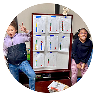 two girls in front of whiteboard with math problems