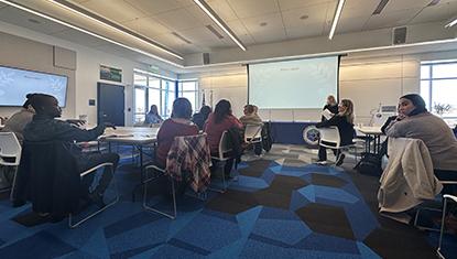 room with people sitting at tables listening to speaker